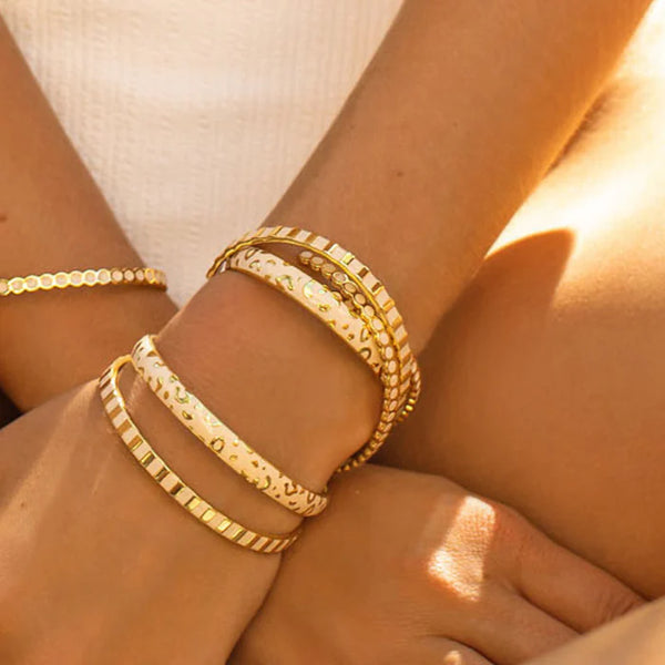 Open and textured bangle in gilded brass and colored lacquer.